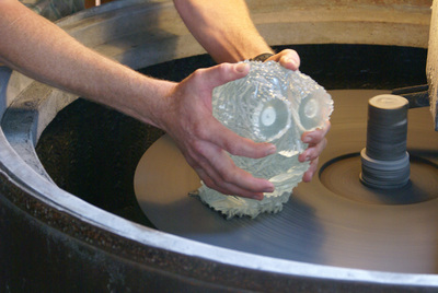 Finally the head is held on the large iron disk and ground with silicon carbide grit to determine the angle of the base.